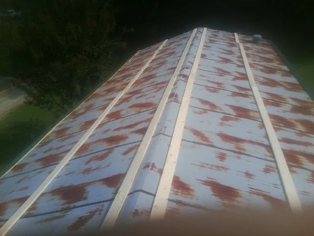 Rusted metal roof panels with new wood purlins before replacement — Storm Damage Roof Repair in New Ross by Roofing Brothers