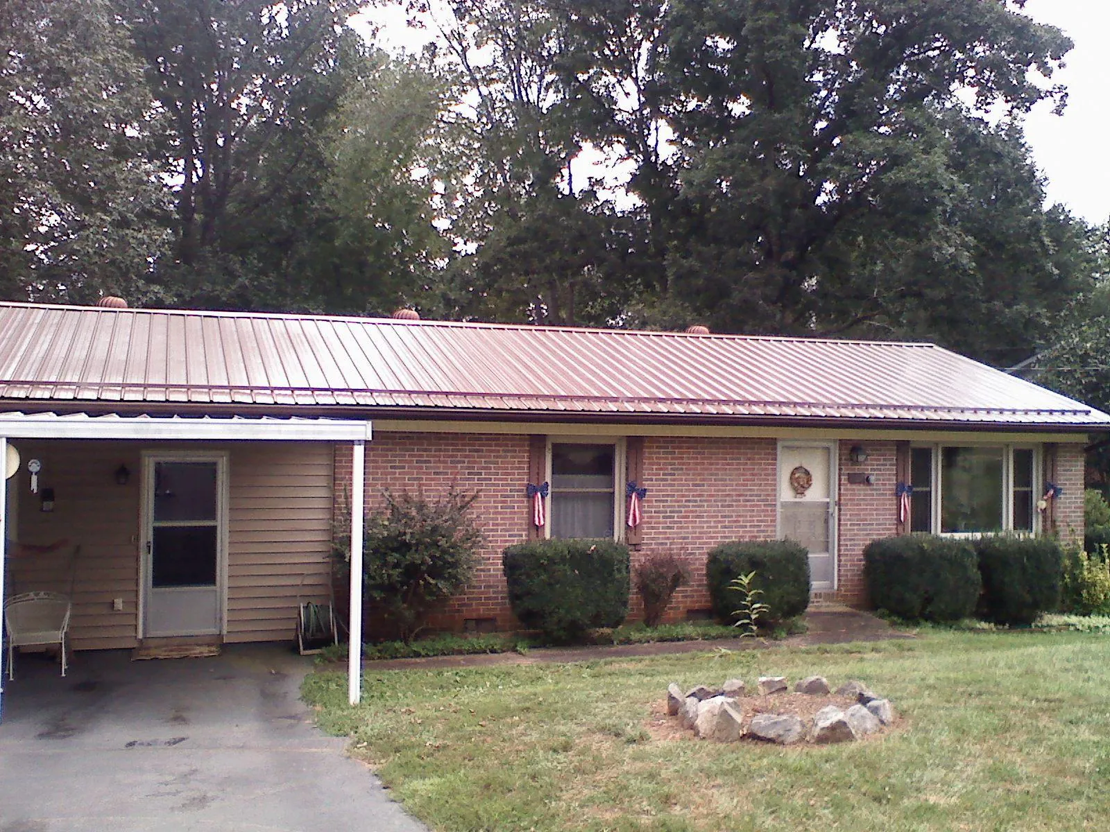 Bronze metal roof and carport on a brick ranch home — Roof Repair work by our crew in New Ross